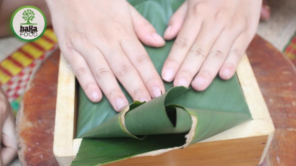 Việc sắp xếp lá trong khuôn gỗ giúp định hình bánh vuông vắn và đẹp mắt
